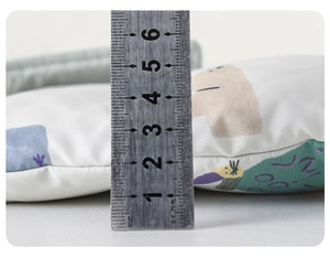 Close-up showing a 5cm thickness measurement of a baby down jumpsuit with a metal ruler