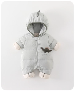 Detail of baby dinosaur romper with embroidered chest patch and 3D spikes on hood