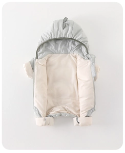 Detail of baby winter jumpsuit featuring thick padding and dinosaur hood with 3D scales