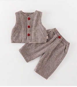 Detail of herringbone fabric boy vest and pants set with red velvet buttons