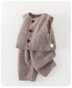 Detail of tweed baby boy vest set with rainbow speckles and red pompom buttons