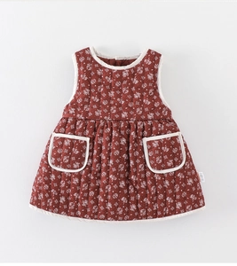 Close-up of baby floral quilted vest dress in dark red with white piping and pockets