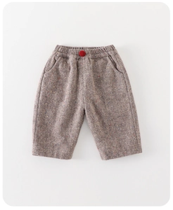 Detail of grey herringbone boy trousers with elastic waist and red decorative button