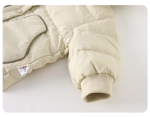 Detail view of ribbed windproof cuffs and pocket binding on beige lightweight kids jacket