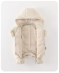 Detail view of baby hooded puffer jumpsuit with zipper and elastic ribbed cuffs in beige