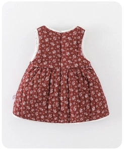 Close-up of quilted floral baby dress featuring red-brown fabric and back zipper detail