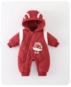 Close-up of red quilted baby romper with dragon embroidery and festive fur details