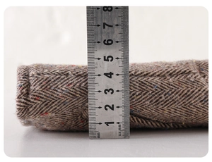 Detail showing 4.5cm thickness of herringbone tweed fabric with steel ruler measurement