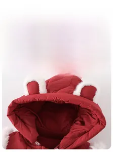Detail of baby winter jumpsuit showing quilted red fabric and cute faux fur bear ears on hood