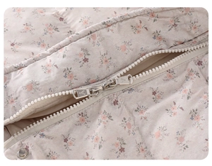 Detail view of floral infant puffer jumpsuit featuring a durable two-way resin zipper