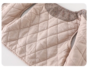 Detailed macro view of beige quilted lining and vintage brown herringbone tweed fabric