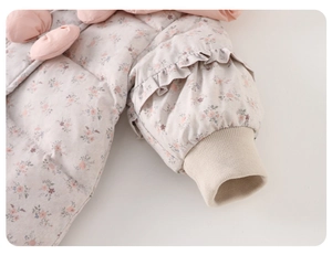 Close-up of floral puffer suit sleeve with frill detail and windproof ribbed cuff
