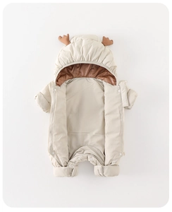 Detail of baby winter romper with cute reindeer antlers and white quilted fabric