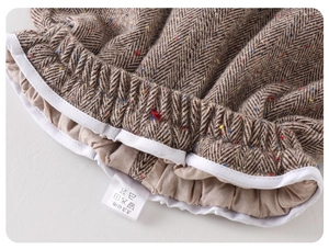 Detail of baby boy winter tweed trousers featuring elastic waist and colorful speckle texture
