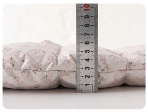 Detail showing the 5cm thickness of the floral quilted baby winter romper suit