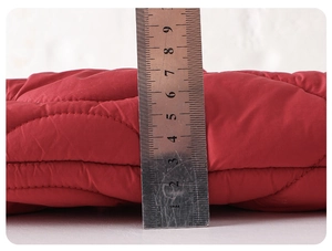 Detail showing the 9cm thickness of the warm red quilted baby winter jumpsuit