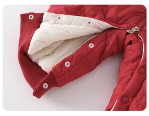 Detail of red quilted baby romper showing metal snaps and thick insulated lining