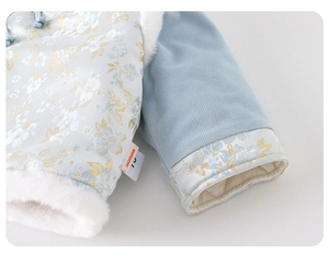 Dettaglio dell'outfit invernale per neonati in jacquard azzurro con bordo in eco-pelliccia