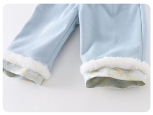 Dettaglio dei pantaloni neonato celesti con bordo in finta pelliccia e fodera in seta