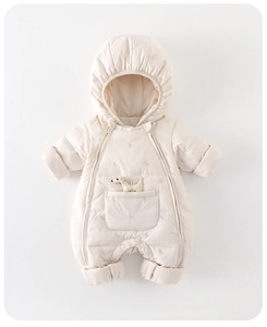 Detail eines gesteppten Baby-Einteilers mit Tiermuster und kleinem Plüschhund-Anhänger