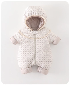 Detailed macro view of baby down romper with floral quilt pattern and ruffle collar detail