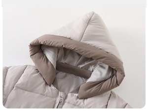 Close-up of baby winter puffer suit with cozy hood, contrast trim and quilted texture