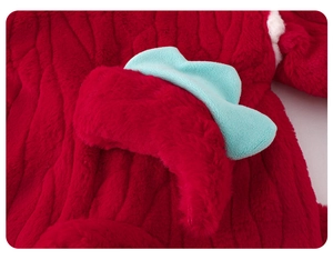 Detail of red plush baby jumpsuit showing soft fleece texture and blue felt appliqué