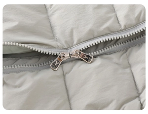 Close-up of dual silver metal zippers on grey quilted winter down romper for babies