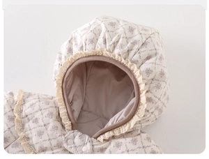 Close-up of baby winter jumpsuit with floral pattern, lace trim, and snap buttons