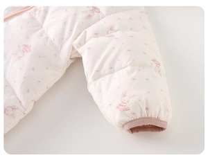 Detailed view of elastic cuffs and cute rabbit floral prints on white baby winter romper