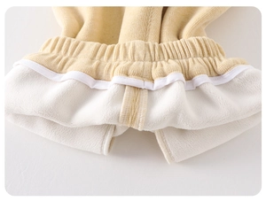 Detailed close-up of thick fleece lining and yellow ribbed elastic waistband on baby pants