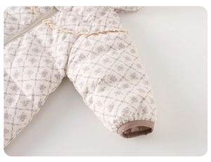 Detail of quilted baby romper with vintage purple floral pattern and lace trim
