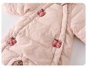 Détail d'une barboteuse matelassée rose pour bébé avec écussons pommes et pressions