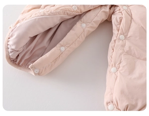 Détail des boutons-pression sur la combinaison matelassée rose pour bébé fille