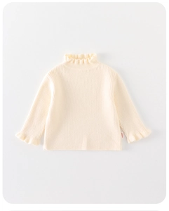 Detail of baby girl knitted sweater with ruffle trim cuffs and high neck in cream white