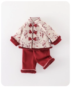 Detail of traditional Chinese New Year outfit featuring beige floral top and red pants