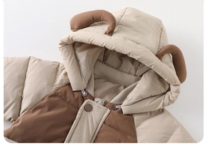 Detail of baby winter romper hood featuring cute 3D brown animal horns and beige fabric
