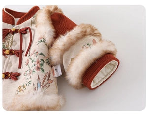 Detail of baby girl New Year outfit with embroidery, faux fur trim and quilted lining