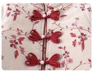 Detail of traditional Chinese knot buckle with pearl on winter jacquard floral outfit