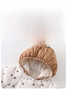 Detail of hooded baby romper with cute pumpkin prints and top leaf decoration