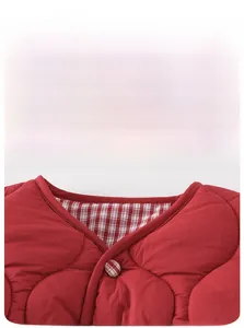 Detail of red quilted vest neckline with checkered lining and fabric covered button