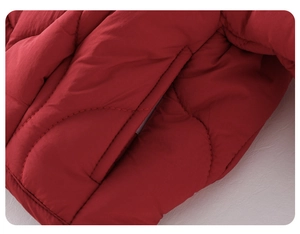 Detailed macro view of red quilted padded jacket showing side pocket and stitching