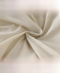 Detail of high-density cream down jacket fabric showing soft texture and premium weave
