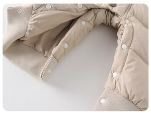 Close-up of baby romper showing quilted windproof fabric, snap closures, and ribbed cuffs