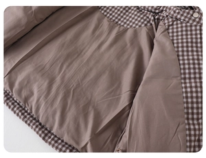 Detailed close-up of brown checkered baby winter jacket with smooth lining and metal button