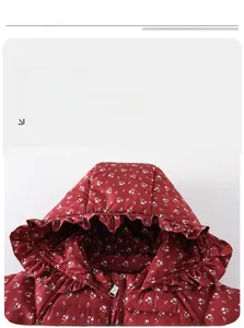 Detail showing the floral pattern and ruffled hood design on the burgundy winter coat