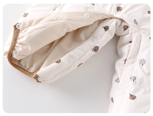 Detail of baby winter romper showing pumpkin prints and resin snap buttons for easy dressing