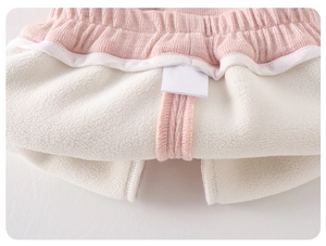 Detail of baby girl winter pants featuring thick white fleece lining and elastic pink waist