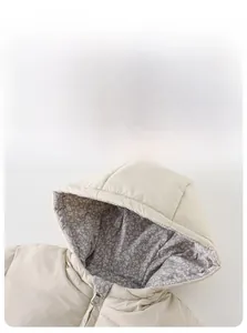 Detail of baby winter coat with floral lining hood and smooth beige polyester fabric