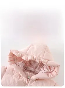 Detail of pink puffer jacket with floral lining and ruffle trim on the hood